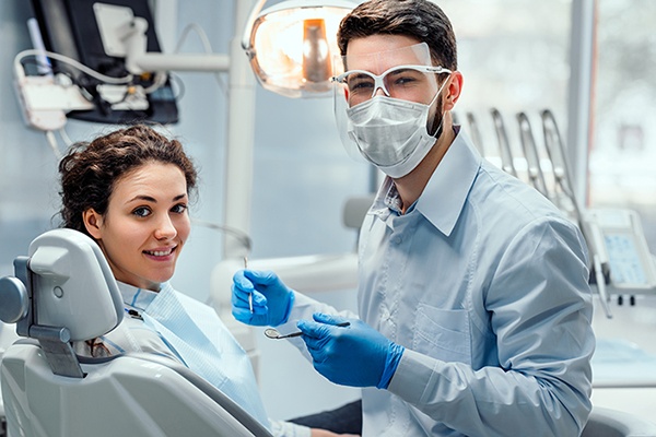 Smiling dentist with patient in dental chair