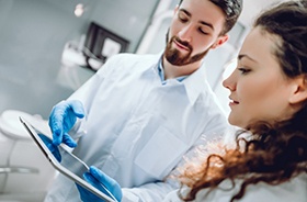 Dentist and patient discussing candidacy for dental implants during consultation