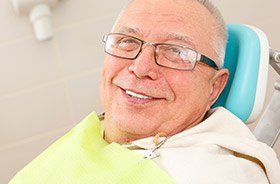 Older man in dental chair smiling