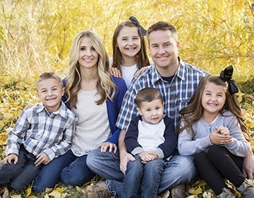 Smiling parents and three children outdoors