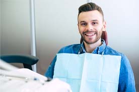 Smiling man in dental chair, attending preventive appointment