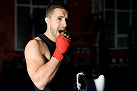 Fit, muscular athlete preparing to put mouthguard in mouth