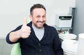 Male dental patient, giving thumbs up for dental care