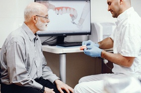 Dentist and senior patient discussing dental implant procedure