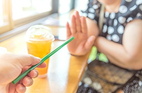 Woman saying no to drinking straw after dental implant surgery