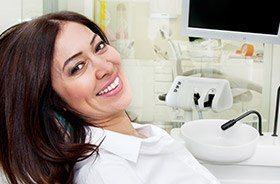 woman smiles after getting dental implant sin Torrington