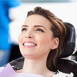Woman smiling while lying back in dental chair