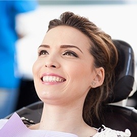 Woman smiling while laying back in dental chair