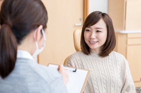 young woman at dental consultation considering cost of Invisalign®