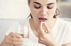 Woman taking antibiotic pill