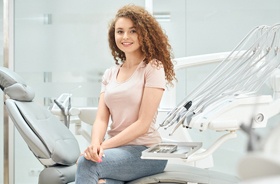 Satisfied female dental patient smiling after root canal therapy