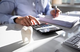 Man sitting at desk, calculating the cost of root canal therapy in Torrington