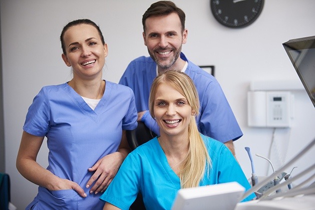 Three smiling dental team members