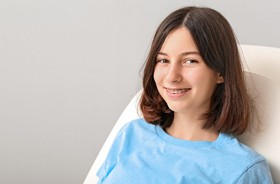 Smiling teen girl wearing braces, attending dental appointment