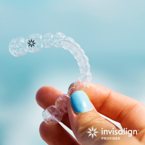close-up of hand holding clear aligner during Invisalign promotion