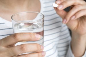 Woman swallowing pill for oral conscious sedation in Torrington