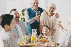 Grateful senior couple with dental implants enjoying dinner with family