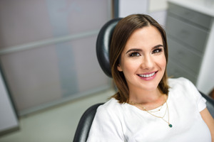 Female dental patient smiling in chair