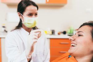 Dental team member showing extracted tooth to patient