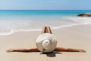 Woman lying on beach, soaking up the sun