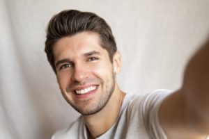 Handsome, smiling man taking a selfie