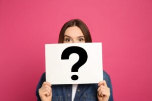 Woman holding a sign with a question mark on it