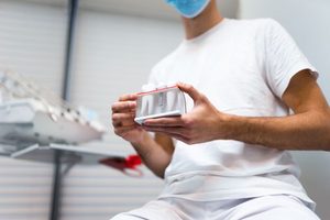 Dentist holding dental implant model